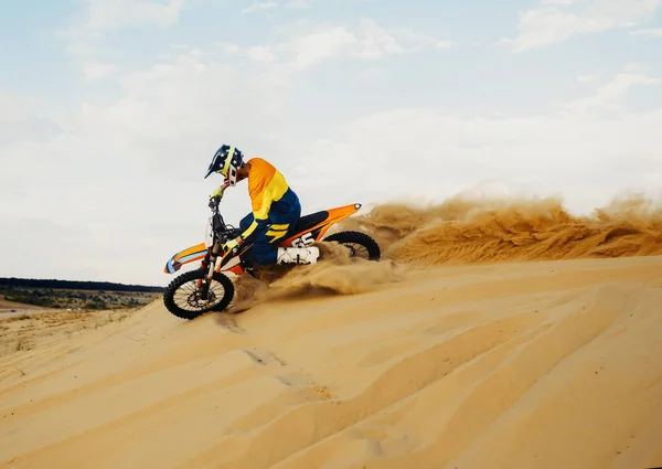 Cavalier professionnel de motocross glissant sur une colline de sable — Photo