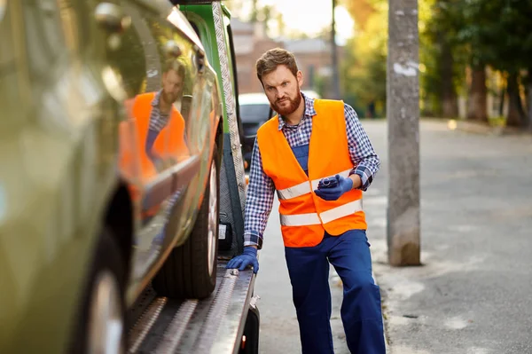 Tow truck worker checking car loading accuracy — 图库照片