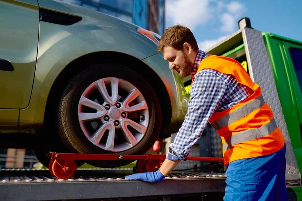 Operador de reboque caminhão fixando o carro na plataforma — Fotografia de Stock