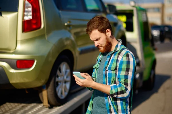 Mannen ringer medan bärgningsbilen hämtar bilen — Stockfoto