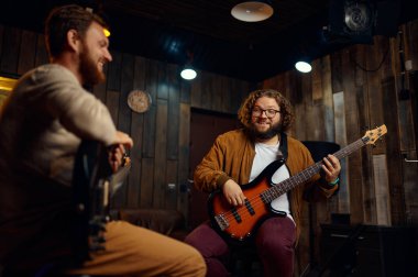 Mutlu gülen arkadaş müzisyen elektro gitar çalıyor.