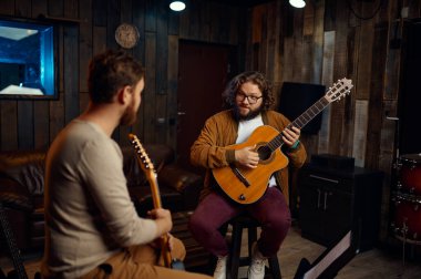 Gitar çalmanın özelliklerini açıklayan müzik öğretmeni