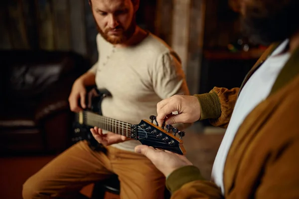 Músico enseñando a un estudiante masculino a tocar la guitarra —  Fotos de Stock