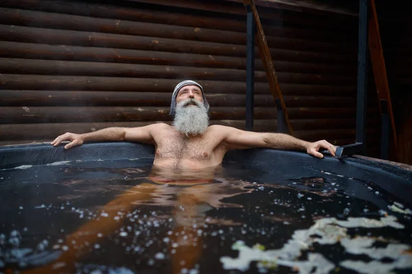 Oudere oudere man rust in bad buiten — Stockfoto