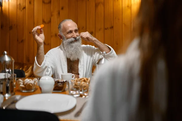 Senior Man Twirling Mustache Sitting Dining Table Flirting Young Woman — Stockfoto