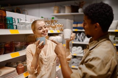 Sevgili çift dükkanda seramik bardak seçiyor.