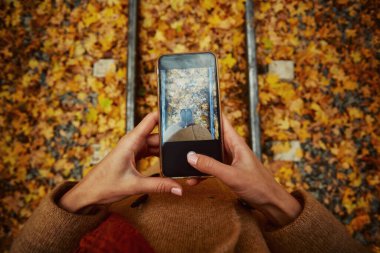 Cep telefonunda bacak fotoğrafı çeken kadın.