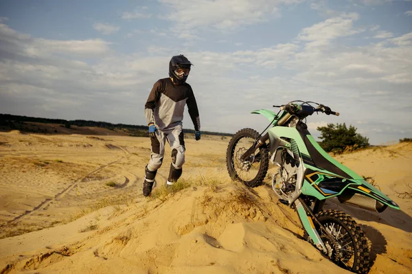 Driver walking to motorbike trapped in sand — ストック写真