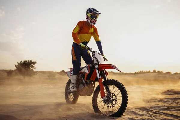 Motocross αναβάτη σε σπορ κινητήρα πάνω από το τοπίο της σκόνης — Φωτογραφία Αρχείου