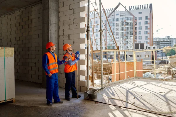 Deux constructeurs debout et parlant de construction — Photo