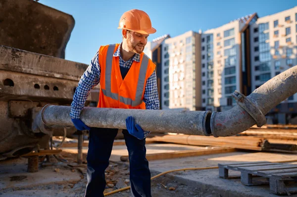 Männlicher Bauarbeiter verbindet Rohr auf Baustelle — Stockfoto