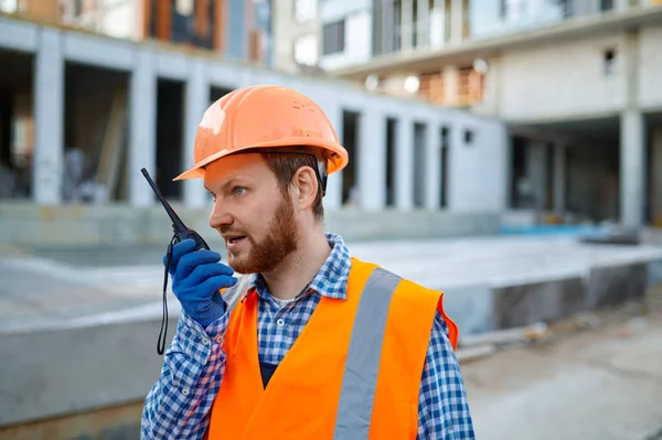 Builder worker using walkie-talkie on construction site — Stock Photo, Image