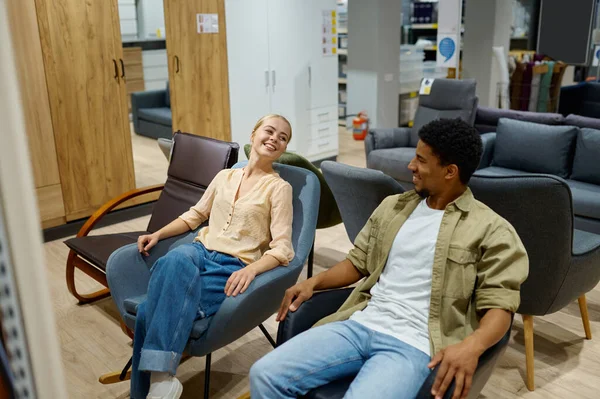 Pareja multiracial en silla en tienda de muebles —  Fotos de Stock