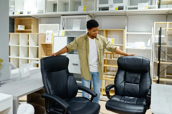 Man choosing office armchairs in furniture store — стоковое фото