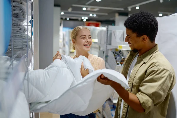 Ευτυχισμένο πολυφυλετικό ζευγάρι αγοράζει κουβέρτα στο κατάστημα — Φωτογραφία Αρχείου