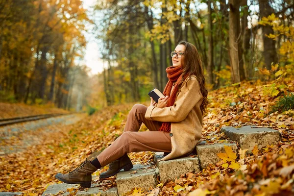 Jeune femme avec livre sur fond d'automne — Photo