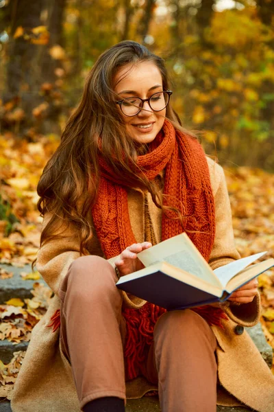Closeup of young woman reading book outdoors — Foto Stock