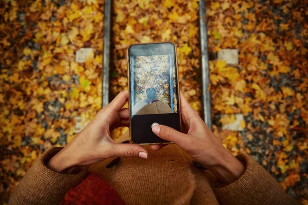 Cep telefonunda bacak fotoğrafı çeken kadın.