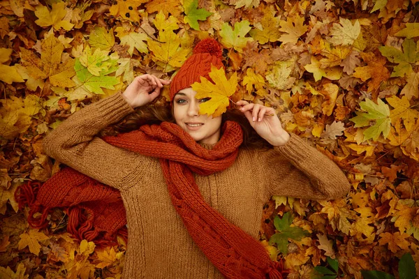 Beautiful happy woman lying on autumn leaves — Stock Photo, Image