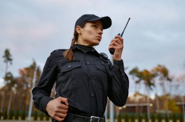 Devriye polisi kadın telsize konuşuyor.