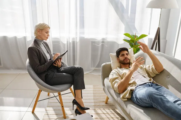 Female psychologist working with man on couch — Stock Photo, Image