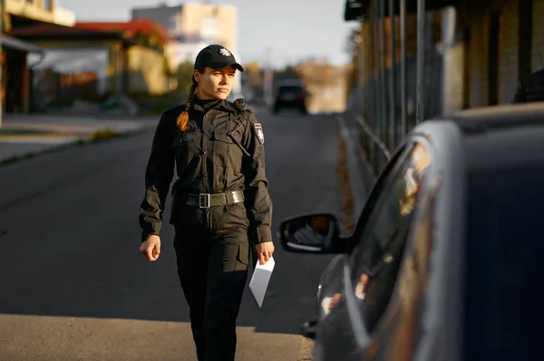 Mulher policial chegando ao carro na estrada — Fotografia de Stock