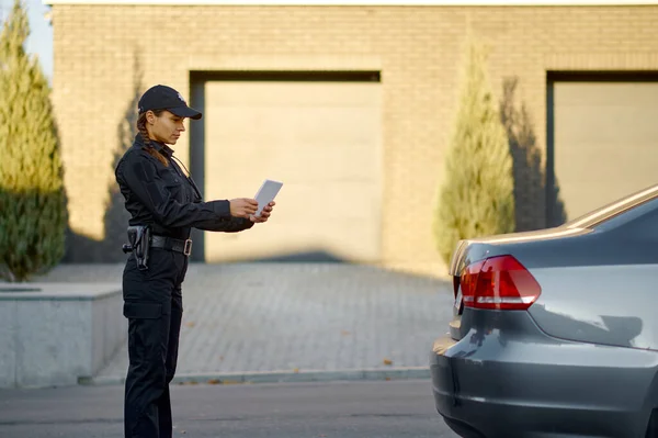 Woman police officer check stopped car number — Stock fotografie