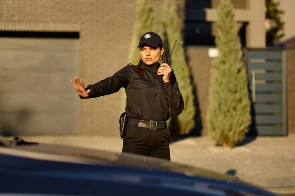 Femme de police utilisant walkie-talkie pour contrôler la circulation routière — Photo