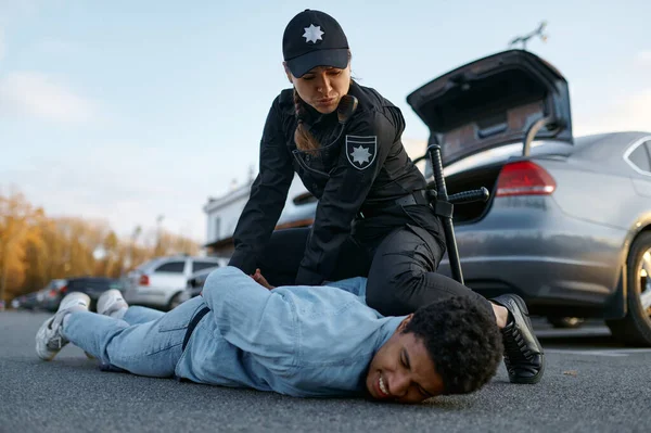 Police officer arresting suspicious young car driver — Stock Photo, Image