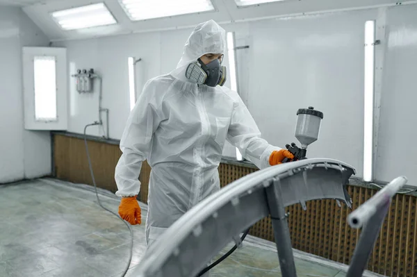 Painter in protective mask painting automobile part — Φωτογραφία Αρχείου