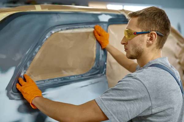 Pintor aplicando papel adhesivo para la protección del coche — Foto de Stock