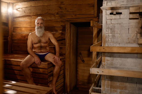 Grijsharige oudere man rust in badhuis — Stockfoto