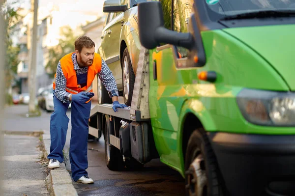 Tow truck worker checking car loading accuracy — Stock Photo, Image