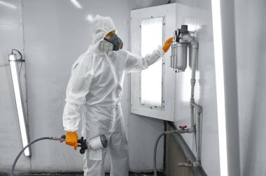 Car painter technician regulating painting gun pressure