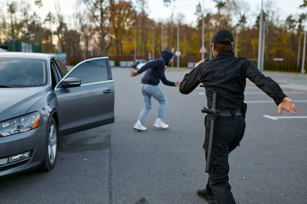 Woman cop running after hooded car thief — Φωτογραφία Αρχείου