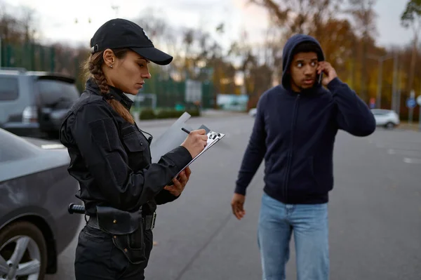 Чоловік і поліцейська жінка роблять штраф — стокове фото