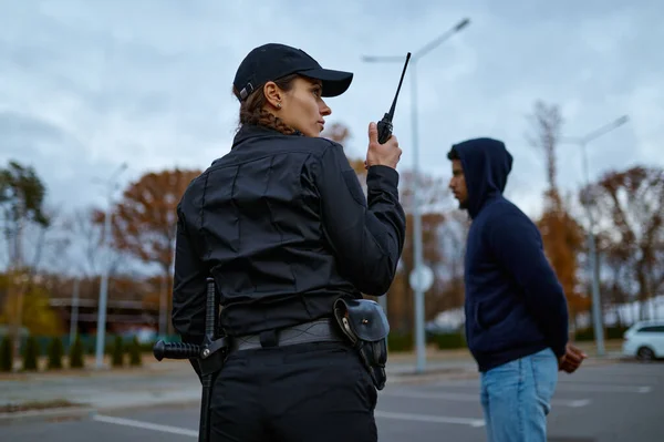 Mujer policía usando radio portátil vista trasera — Foto de Stock