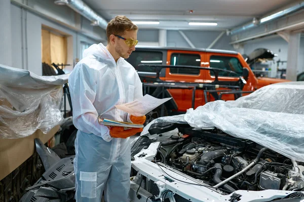 Young man mechanic looking at car engine — Stok fotoğraf