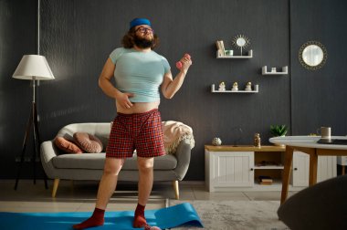 Sabah dambıllarla antrenman yapan komik adam.