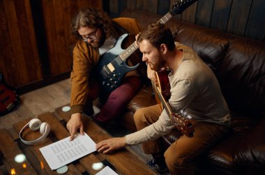 Eğitmen insana evde gitar çalmayı öğretiyor.