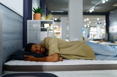 Yatağı seçen adam ortopedik yatak yumuşaklığını kontrol ediyor.