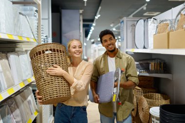 Çamaşır sepeti ve ütü masası alan çift