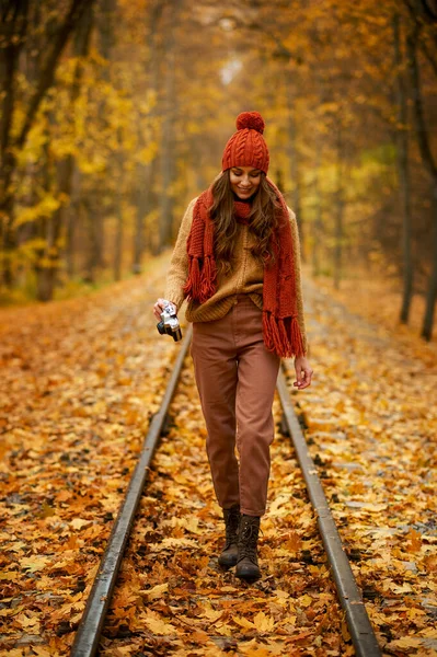 Woman walking with camera in autumn park — Stock Photo, Image