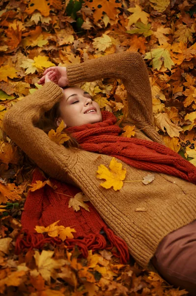Gelukkig mooi vrouw liggend op herfst bladeren — Stockfoto