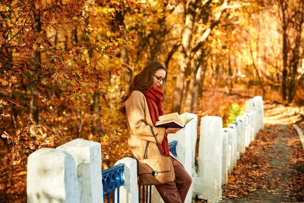 가을 공원에 책을 가지고 있는 젊은 여자 — 스톡 사진