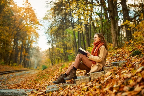 Young woman with book over autumn background — Foto Stock