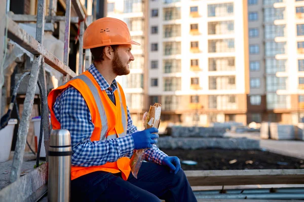 Construction worker eating sandwich during lunch break — Stock Photo, Image