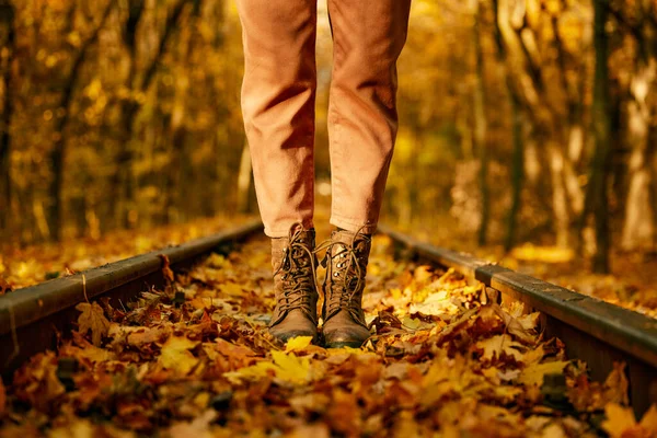 Female fashion boots over autumn railroad tack — 图库照片