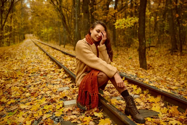 Femme assise sur la voie ferrée tenant la tête — Photo