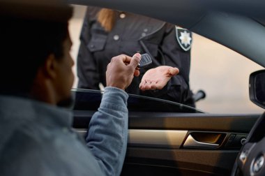 Kapalı araba sürücüsü anahtarı kadın polise veriyor.